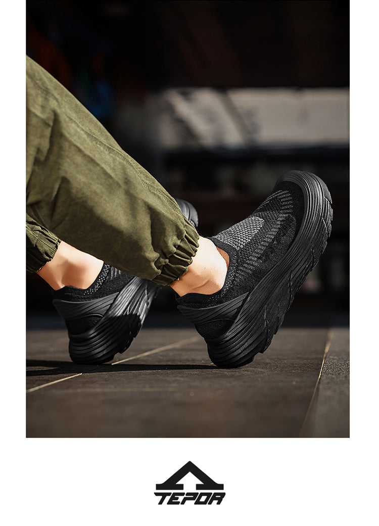 A person wearing black casual sports shoes, showcasing the shoes' design and fit when worn.