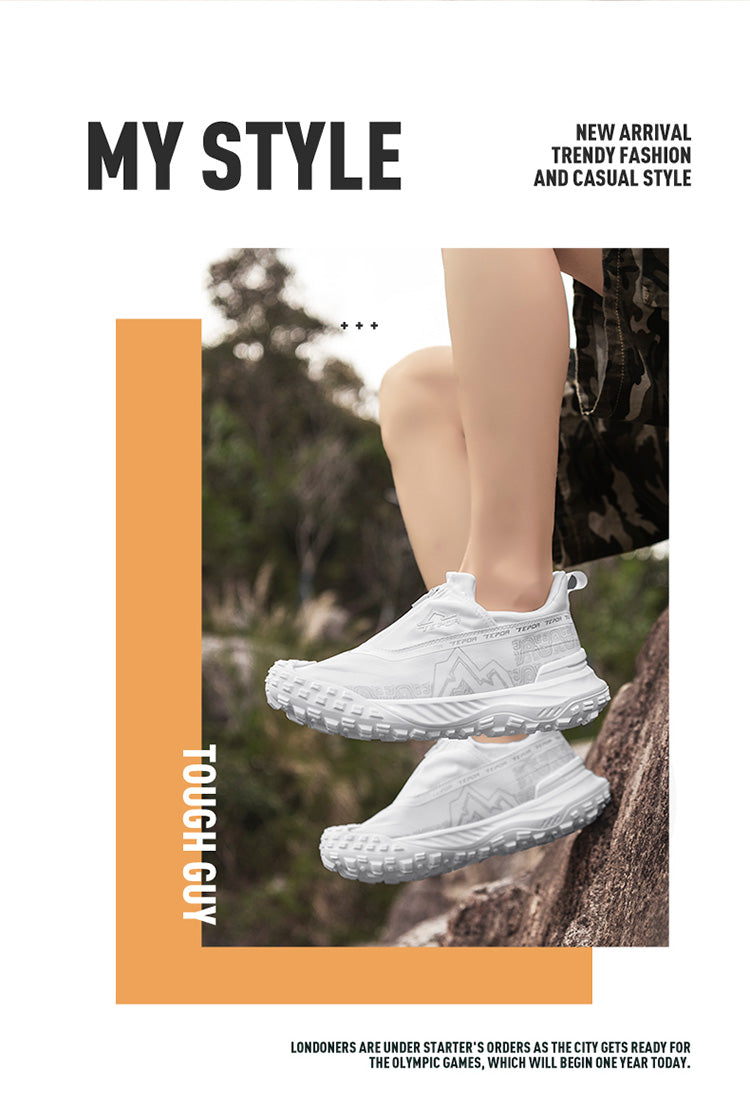 A pair of white outdoor casual shoes worn by a person, positioned on a rock in a natural outdoor setting with greenery, highlighting their stylish and practical design for outdoor activities.

